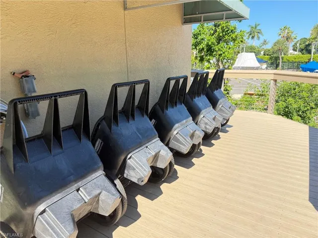 Exterior deck area featuring a composite wood-finish surface, cable railing, and a beige stucco wall