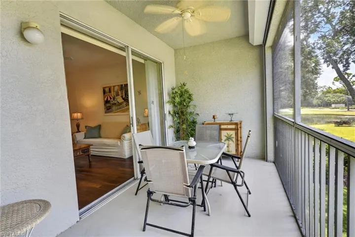 Screened balcony featuring a ceiling fan, a painted concrete floor, and a sliding glass door providing access to the interior with wood-finish flooring