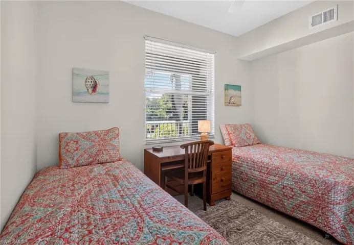 Light-filled room featuring a large window with blinds, neutral wall tones, and carpet flooring