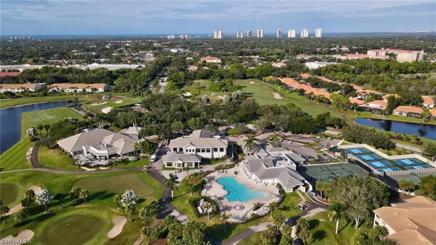 Aerial perspective featuring a golf course, expansive club facilities, multiple tennis courts, and a large swimming pool