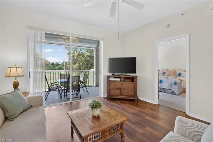 Living area featuring wood-finish flooring and a ceiling fan