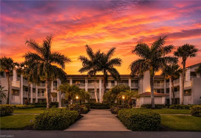 Multi-story residential building with private balconies and Mediterranean-style tile roofing