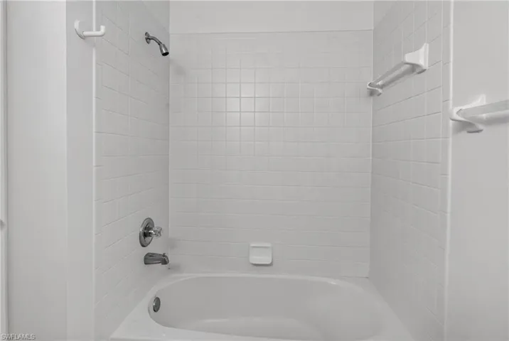 White tiled shower and bathtub combination with chrome fixtures