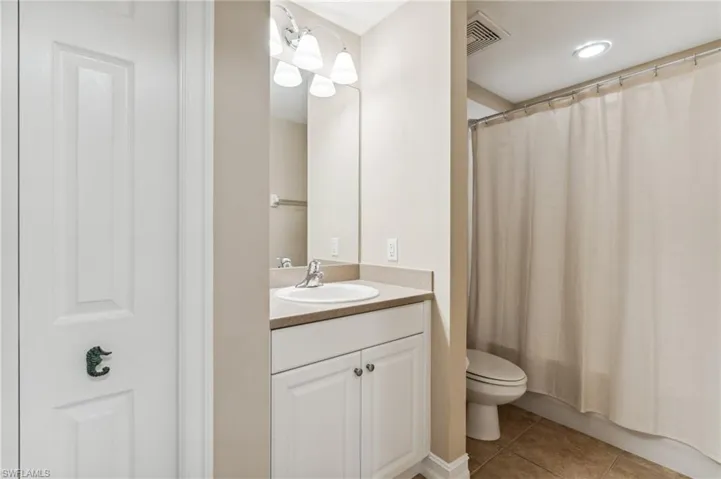 Full bathroom featuring vanity, shower / tub combo, toilet, and tile patterned floors