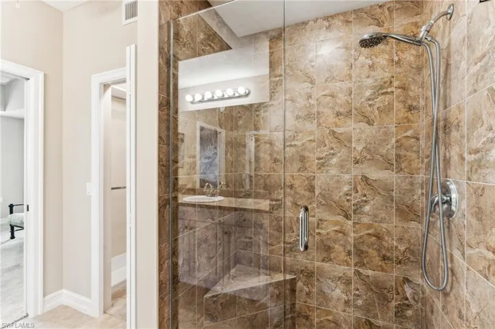 Bathroom with walk in shower and tile patterned floors