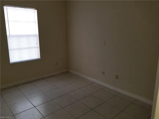 Spare room with baseboards and light tile patterned floors