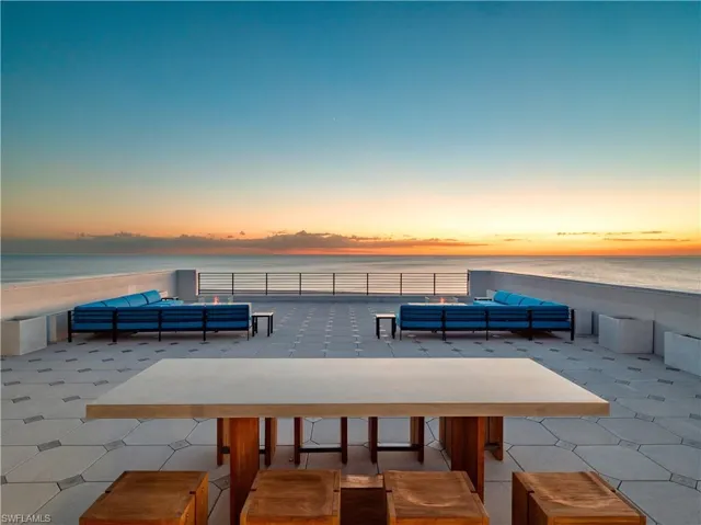 Patio terrace at dusk with a water view and outdoor lounge area
