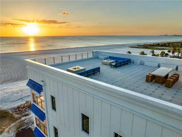 Patio terrace at dusk with a water view and a beach view
