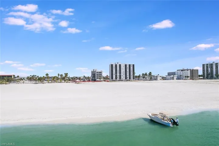 Birds eye view of property featuring a water view and a beach view