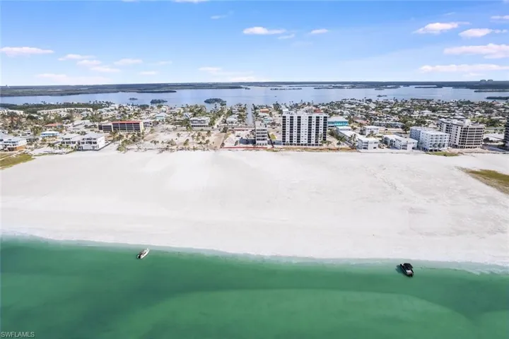 Birds eye view of property featuring a water view and a beach view