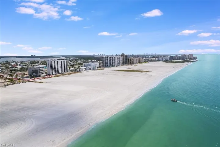 Birds eye view of property featuring a water view and a beach view