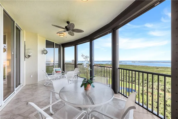 Sunroom / solarium featuring a water view and ceiling fan