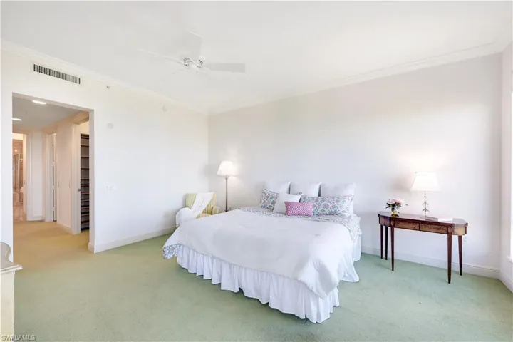 Carpeted bedroom featuring crown molding and ceiling fan
