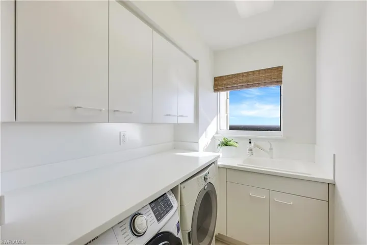 Washroom featuring cabinets, washing machine and dryer, and sink