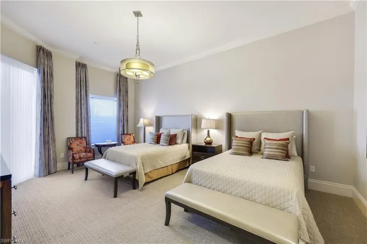 Carpeted bedroom with ornamental molding