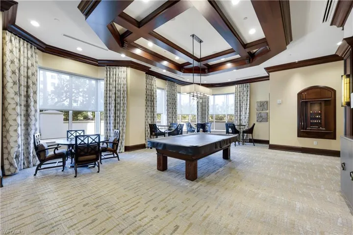 Game room with ornamental molding, light carpet, and beam ceiling
