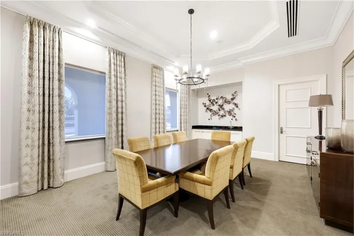 Dining space featuring light carpet, ornamental molding, and a chandelier