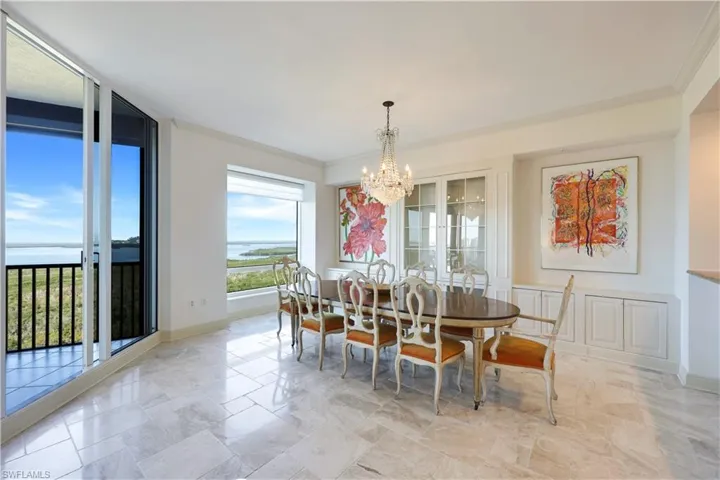 Dining room with an inviting chandelier, ornamental molding, and expansive windows