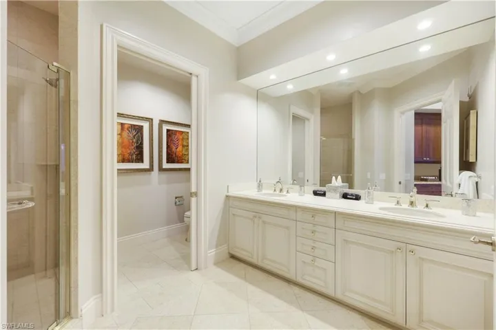 Bathroom featuring vanity, an enclosed shower, ornamental molding, tile patterned floors, and toilet