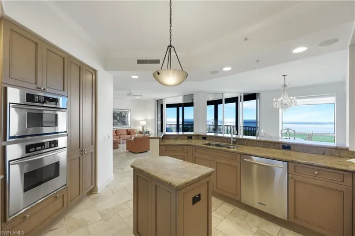 Kitchen with pendant lighting, sink, a kitchen island, and appliances with stainless steel finishes