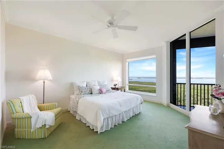 Carpeted bedroom with ornamental molding, a water view, access to outside, and ceiling fan
