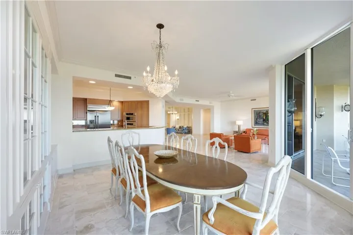 Dining space with ornamental molding and ceiling fan with notable chandelier