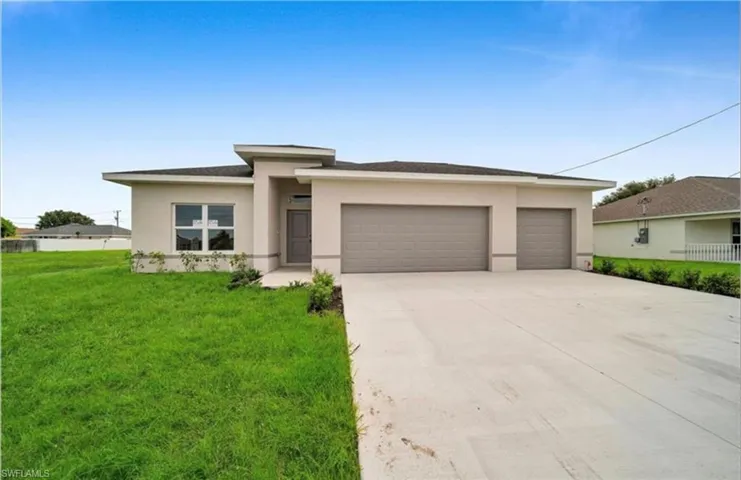 Prairie-style home with driveway, a front yard, and stucco siding