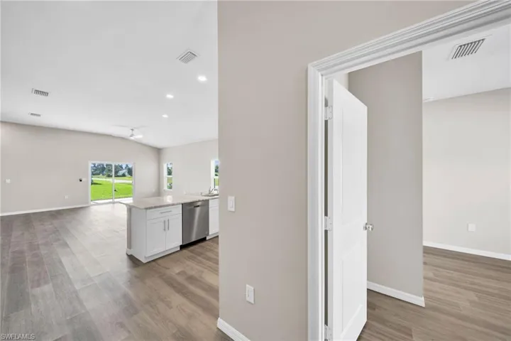 Kitchen with open floor plan, stainless steel dishwasher, light wood-type flooring, and visible vents