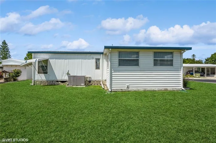 Back of property featuring a yard