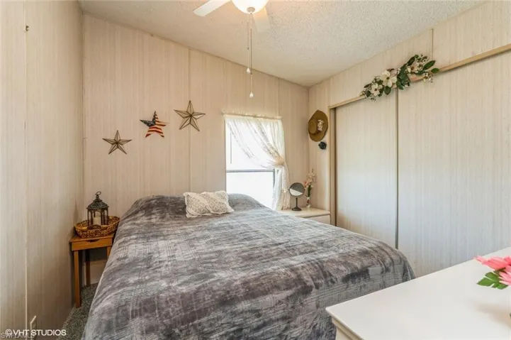 Bedroom featuring a textured ceiling, ceiling fan, a closet, and wallpapered walls