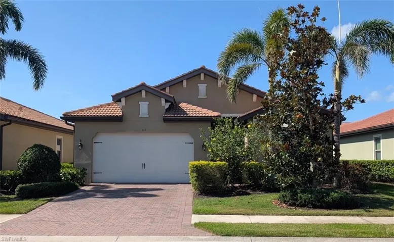 Mediterranean / spanish home with decorative driveway, stucco siding, a tile roof, and a garage