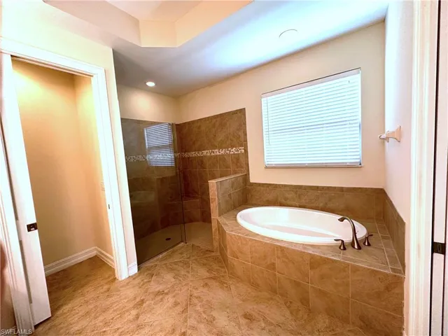 Full bath with a bath, walk in shower, tile patterned floors, and recessed lighting