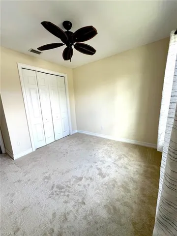2nd Bedroom with brand new carpet, ornamental molding, a tray ceiling and a ceiling fan.
