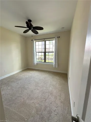 Bedroom with light carpet and a ceiling fan