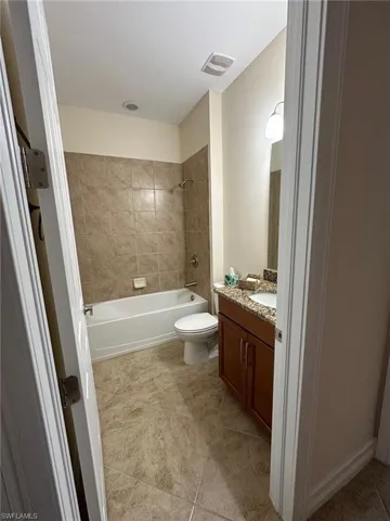 Full bathroom featuring vanity, bathtub / shower combination, and light tile patterned flooring