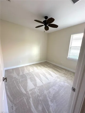 3rd Bedroom with brand new carpet,  ornamental molding, a tray ceiling and a ceiling fan.