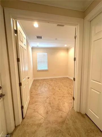 Hallway featuring ornamental molding, recessed lighting, and light tile patterned flooring