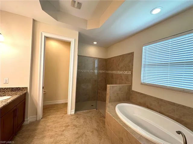 Spacious Master bath featuring a soaking tub, frameless shower, private water closet and tray ceiling.