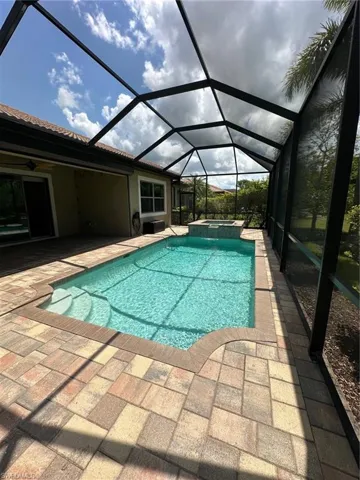 View of swimming pool with a pool with connected hot tub, a ceiling fan, large patio area