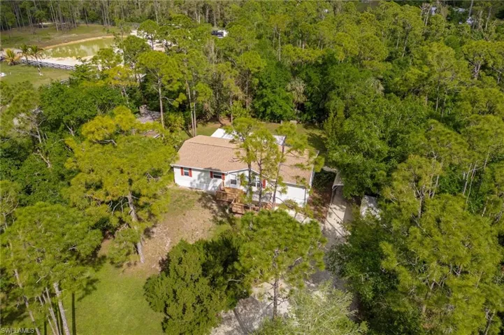 Birds eye view of property with a water view and a forest view