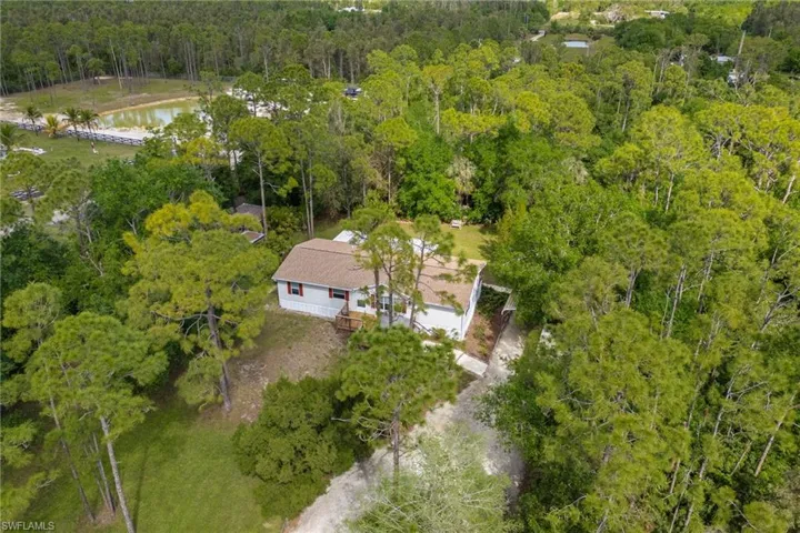 Drone / aerial view with a water view and a view of trees