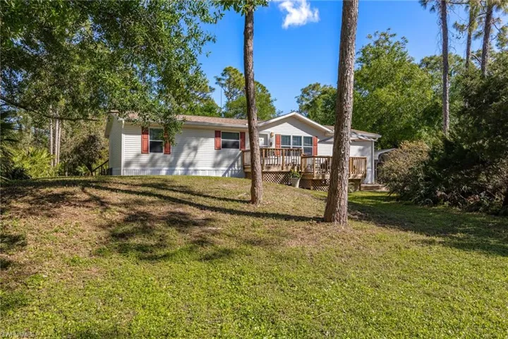 View of front of home with a front yard and a wooden deck