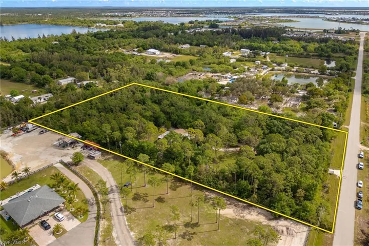 Birds eye view of property featuring a water view and a wooded view