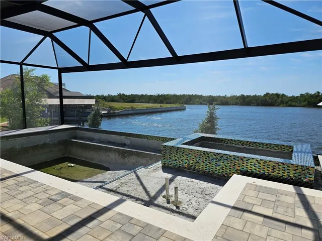Electric heated pool with oversized 6-person 360 spa, sparkling glass tile, automation, sun-shelf, false negative edge and pool cage with a huge picture window