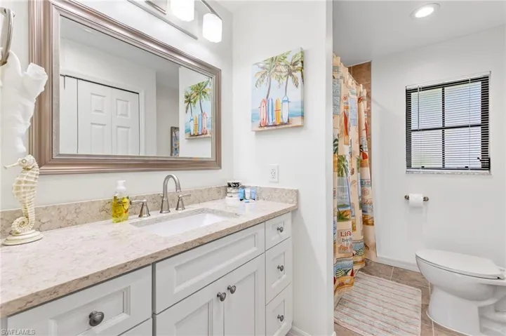 Bathroom with tile flooring, vanity, and toilet