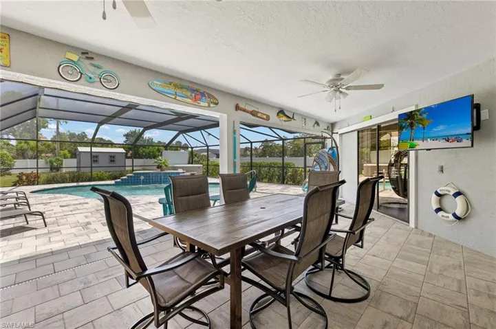 View of patio featuring glass enclosure and ceiling fan