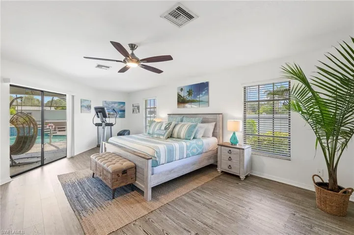 Bedroom featuring wood-type flooring, ceiling fan, and access to outside