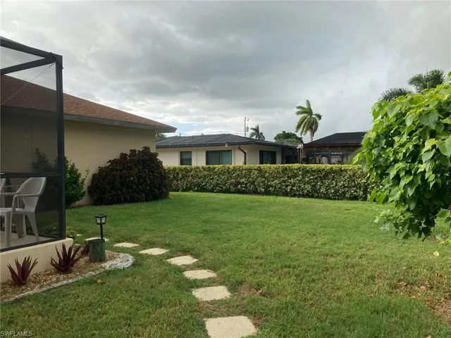 View of green lawn featuring glass enclosure