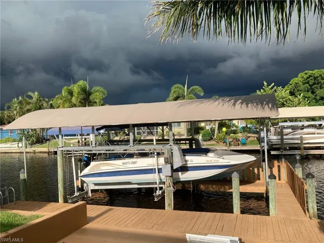 Dock area featuring boat lift and a water view