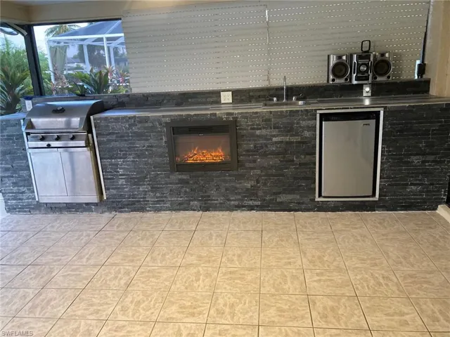 View of patio / terrace with area for grilling and a lanai